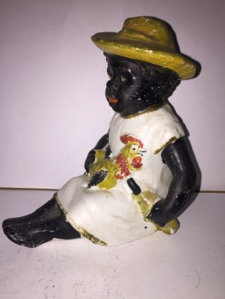 Black Americana Bisque Figure Of A Man Sitting Holding A Bottle And Chicken.