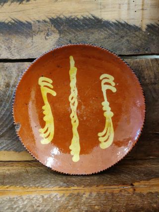 Early primitive redware plate with a pretty slipware design and great color. 2