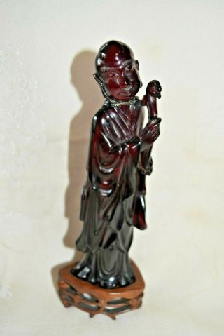 Antique Chinese Dark Red Cherry Amber Figurine Of Man With Carving Wood Base