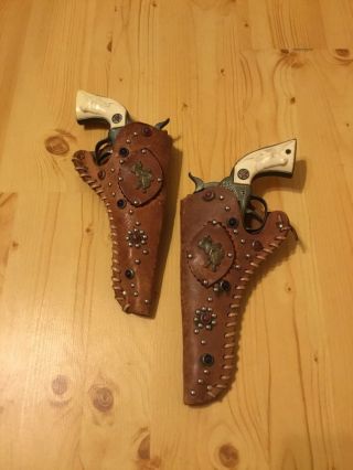 (2) Large Vintage Hubley ”cowboy” Cap Guns With Jeweled Leather Holsters