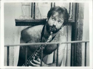 Press Photo Shirtless Bearded Robin Williams Plays Saxophone Out Window