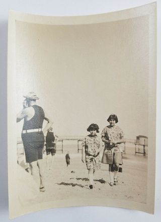 Snapshot Photograph Two Girls Walking On Beach Men In Bathing Suits Ocean 1920s