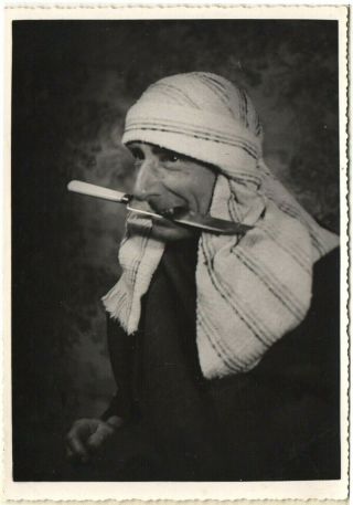Comic Photograph Of A Man Dressed As An Arab Holding A Large Knife In His Teeth.
