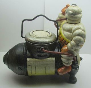 Michelin Man Sitting On A Compressor Coin Bank