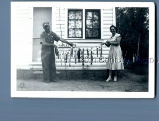 Black & White Photo I,  1959 Man And Woman In Dress Holding Fish On String
