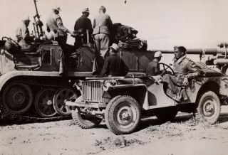 Wwii German Press Photo German Afrikakorps Soldier In Captured Jeep Near Sdkfz 7