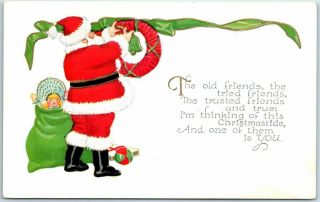 Vintage Christmas Embossed Postcard Santa Claus Hanging Red Wreath C1910s