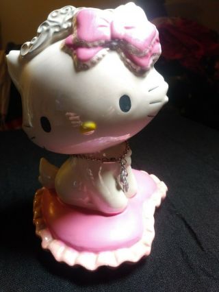 Hello Kitty Piggy Bank Vintage Sitting On A Pink Pillow With A Key Around Her.