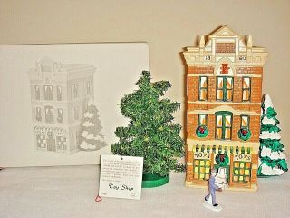 Dept 56 Snow Village Toy Shop Store With Man With Gifts Figurine And Tree