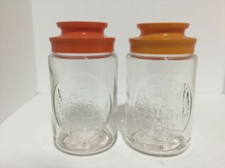Two Vintage Anchor Hocking Glass Tang Jars Cabin And Water Wheel Orange Lids