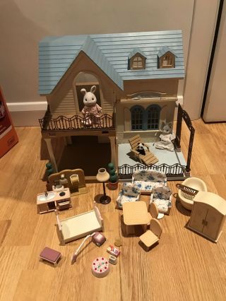 A Two Story Sylvanian House With Furniture And 2 Figures