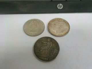1882 Morgan Silver Dollar,  1964 Bermuda Siver Crown,  1873 Trade Token?