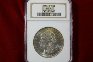 1884 - O United States Morgan Silver Dollar,  Ngc Ms62,  Gold Toning Starting,