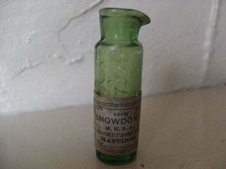 A Small Green Glass Hastings Chemist Bottle,  Embossed Name & Paper Label.