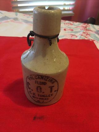 C.  O.  T Vulcanizing Fluid C.  O.  Thigley Rahway N.  J.  Stoneware Bottle With Wire Bail